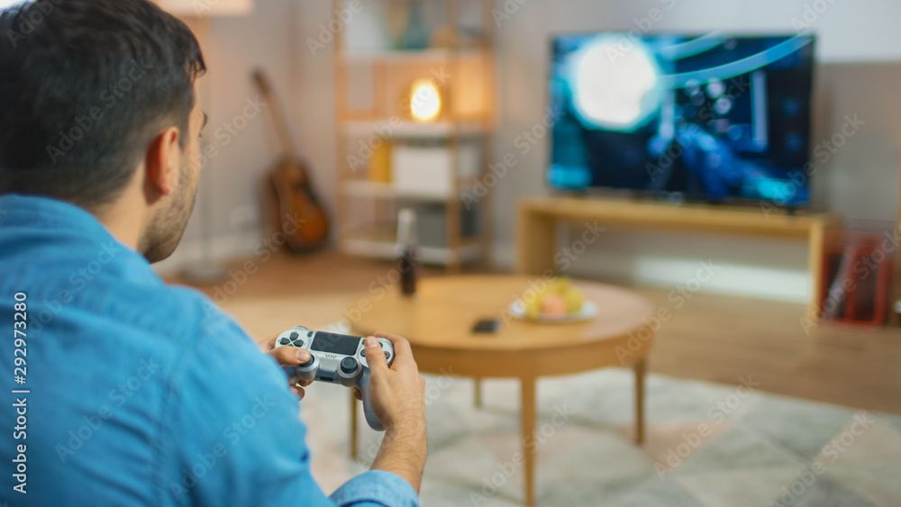 在客厅里，一个坐在沙发上的男人拿着控制器在控制台上玩电子游戏，3D Actio