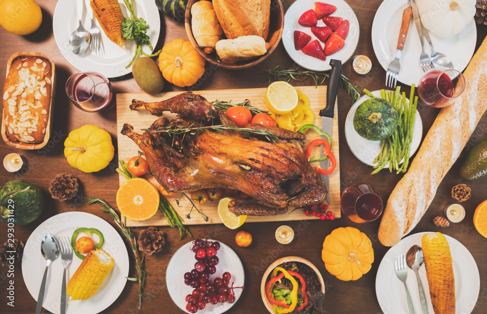餐桌上有火鸡的家庭和食物的快乐感恩节晚宴