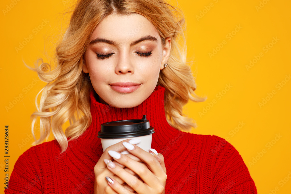 快乐、情绪化、开朗的女孩穿着针织秋季毛衣和彩色yel上的一杯咖啡大笑