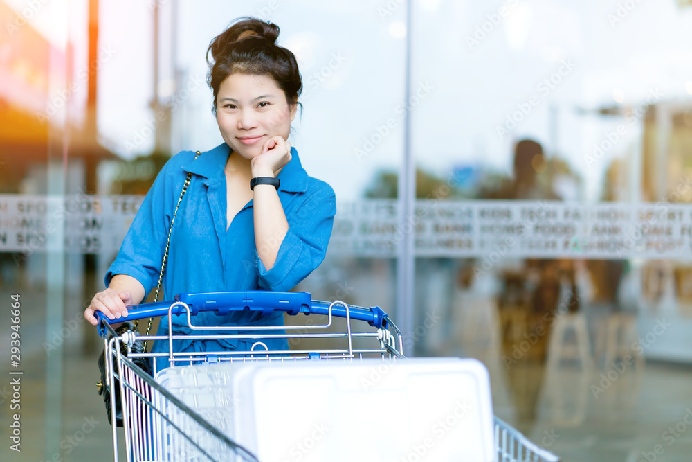 亚洲美女带着购物车享受购物商业消费理念