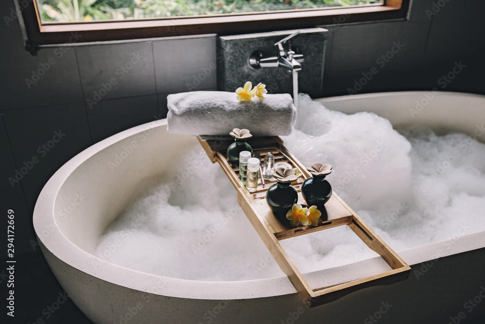 泡沫浴缸充满水，浴缸上有美容产品。