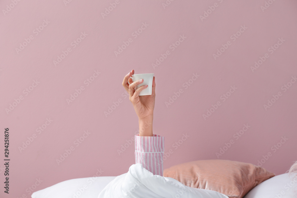 躺在床上喝着咖啡的年轻女人