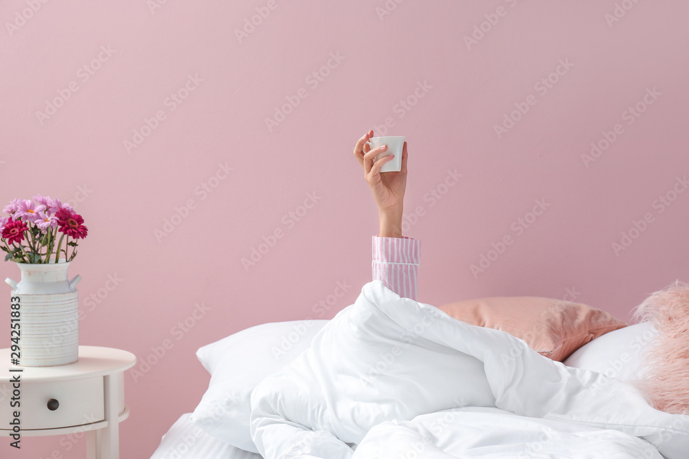 躺在床上喝着咖啡的年轻女人