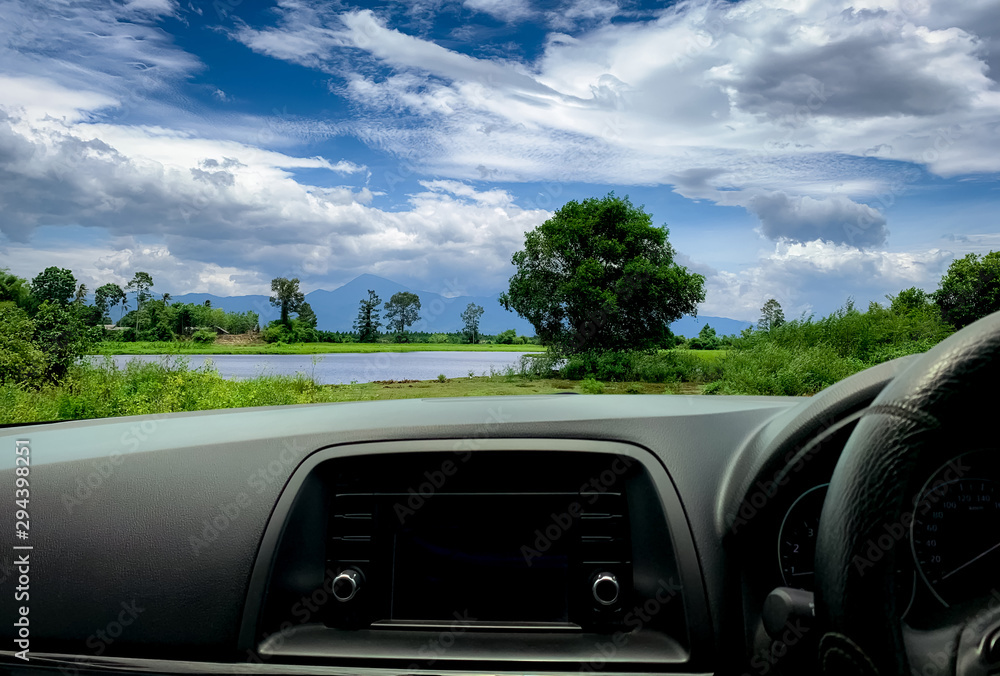 从车内观看Beatuful景观。汽车内部的方向盘和仪表板。公路旅行特拉