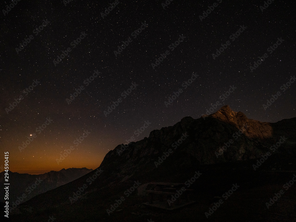 日落几乎没有照亮朱利安阿尔卑斯山星空下的岩石山顶。