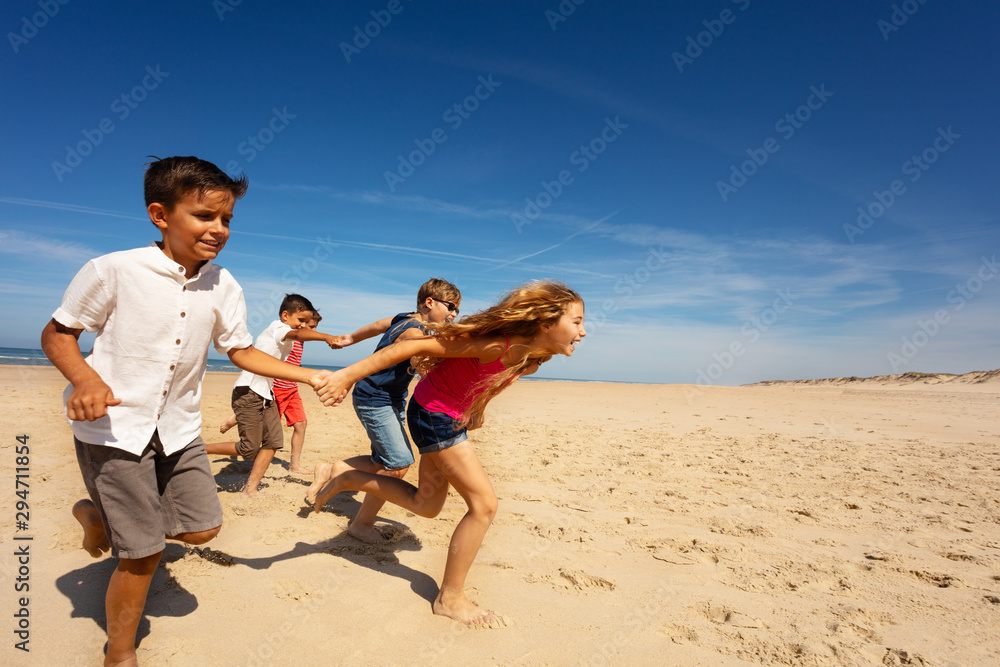 一群孩子在海边沙滩上快速奔跑取乐