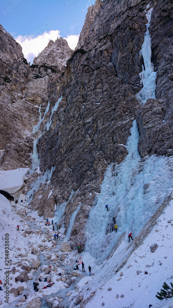 无人机：在登山者攀登冰冻瀑布的山附近飞行