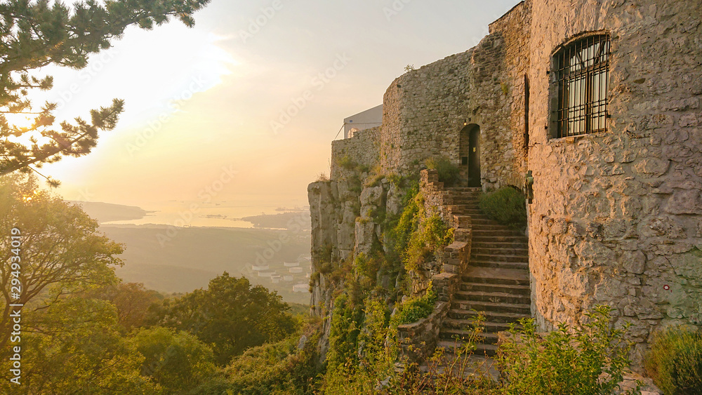 金色的傍晚阳光照射在斯洛文尼亚海边一座古老的中世纪城堡上