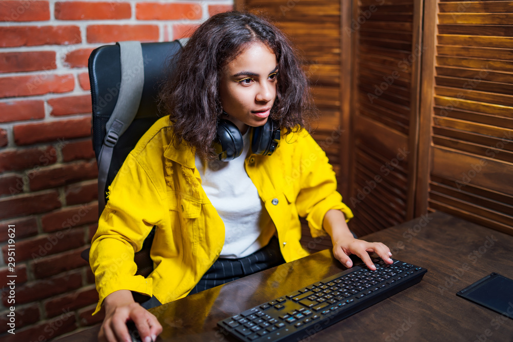 年轻漂亮的女人坐在一台打开的笔记本电脑前。现代年轻的商业女性正在工作