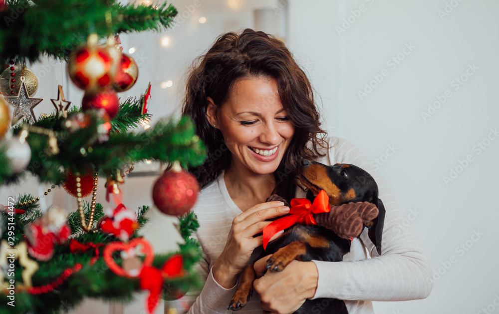 一个兴奋的女人在圣诞节收到小狗的画像。