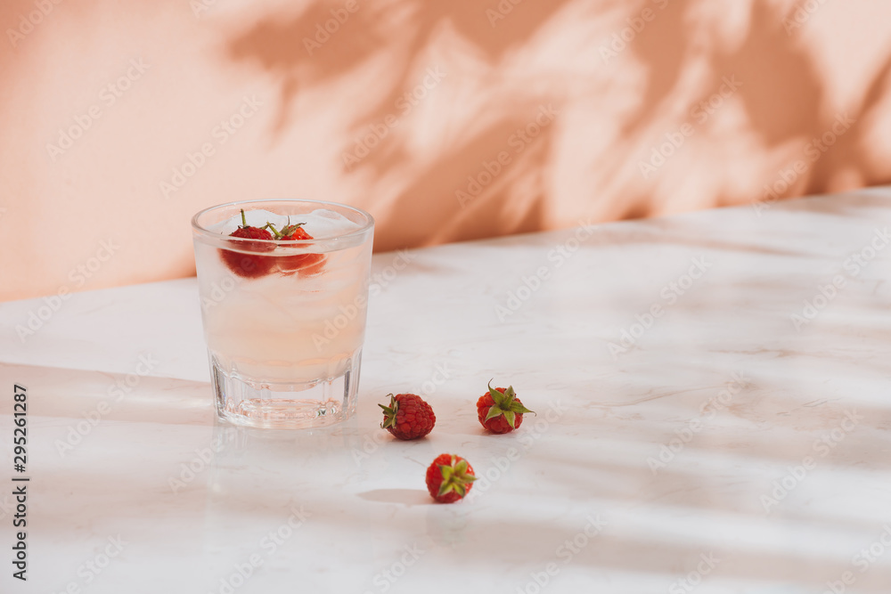 夏季果汁配新鲜树莓，装在玻璃杯中，背景为浅色
