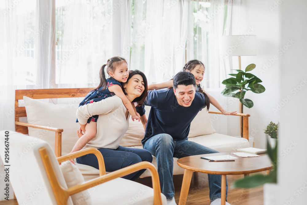 快乐的亚洲家庭一起在沙发、家庭客厅玩耍