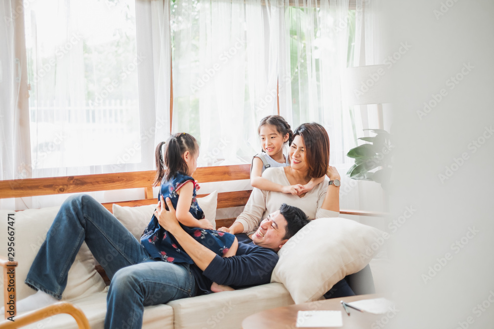 快乐的亚洲家庭一起在沙发、家庭客厅玩耍
