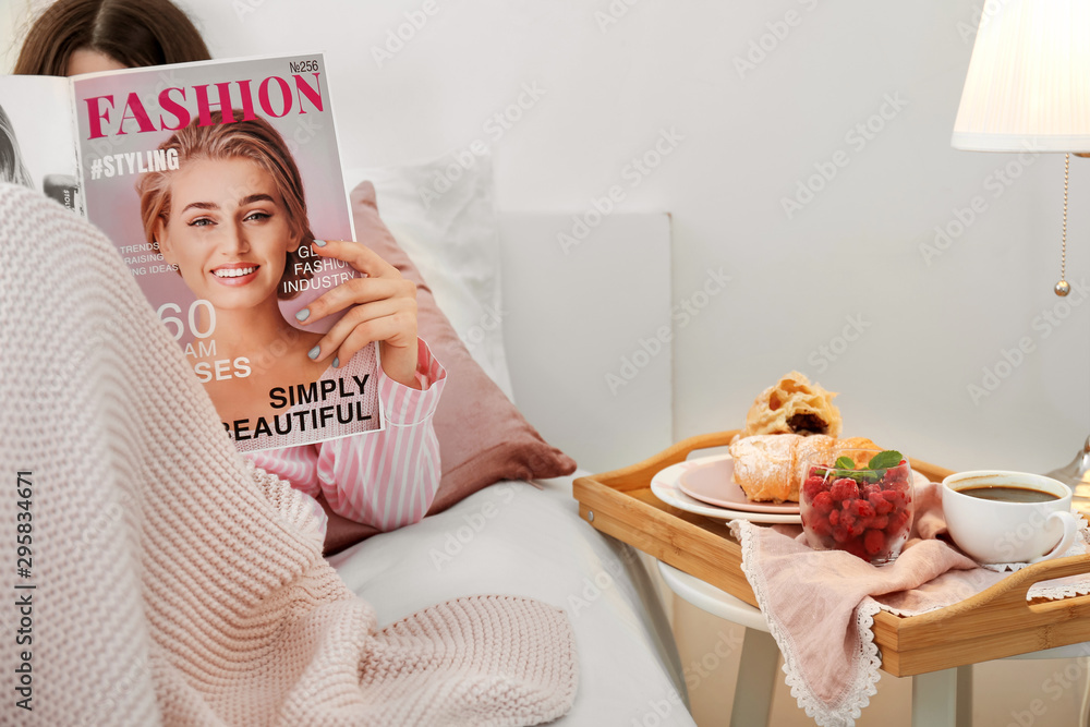 女人在卧室早餐前阅读时尚杂志