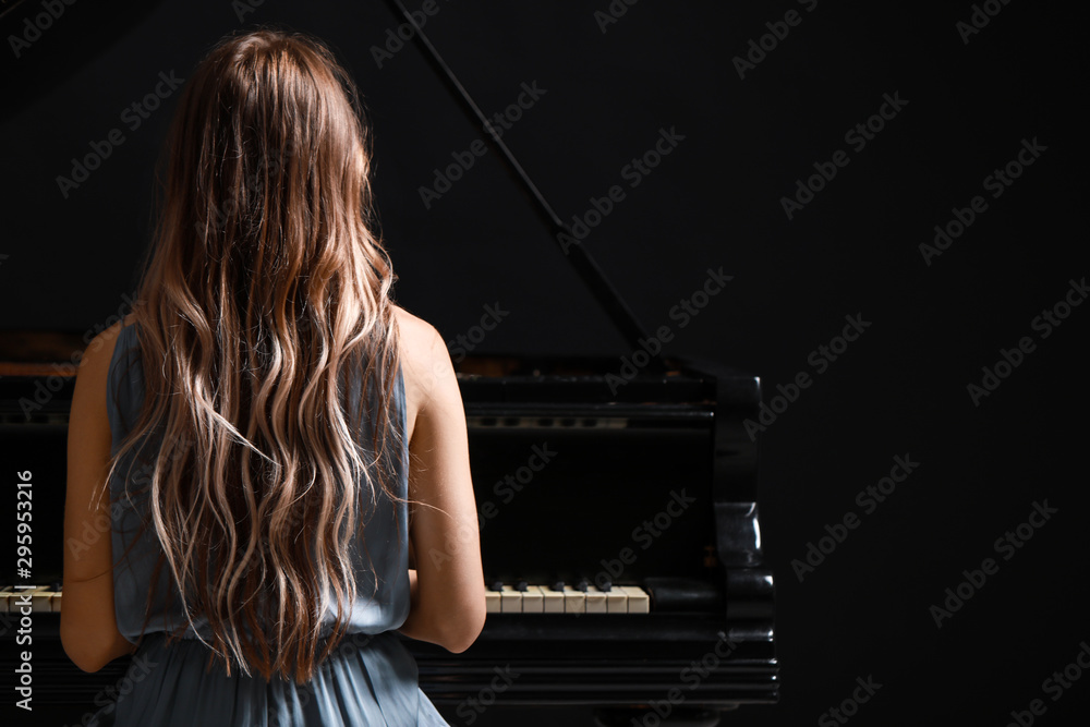年轻女子在音乐会上弹奏三角钢琴