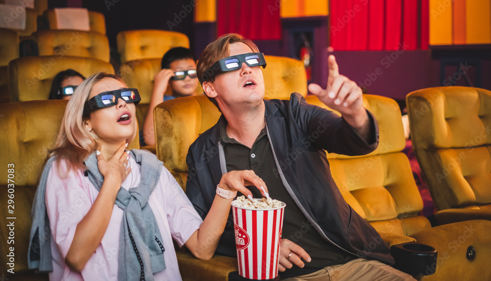 快乐的年轻情侣在影院/影院观看动作片，3D
