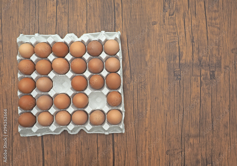 木桌上有很多鸡蛋在包装中。俯视图。
