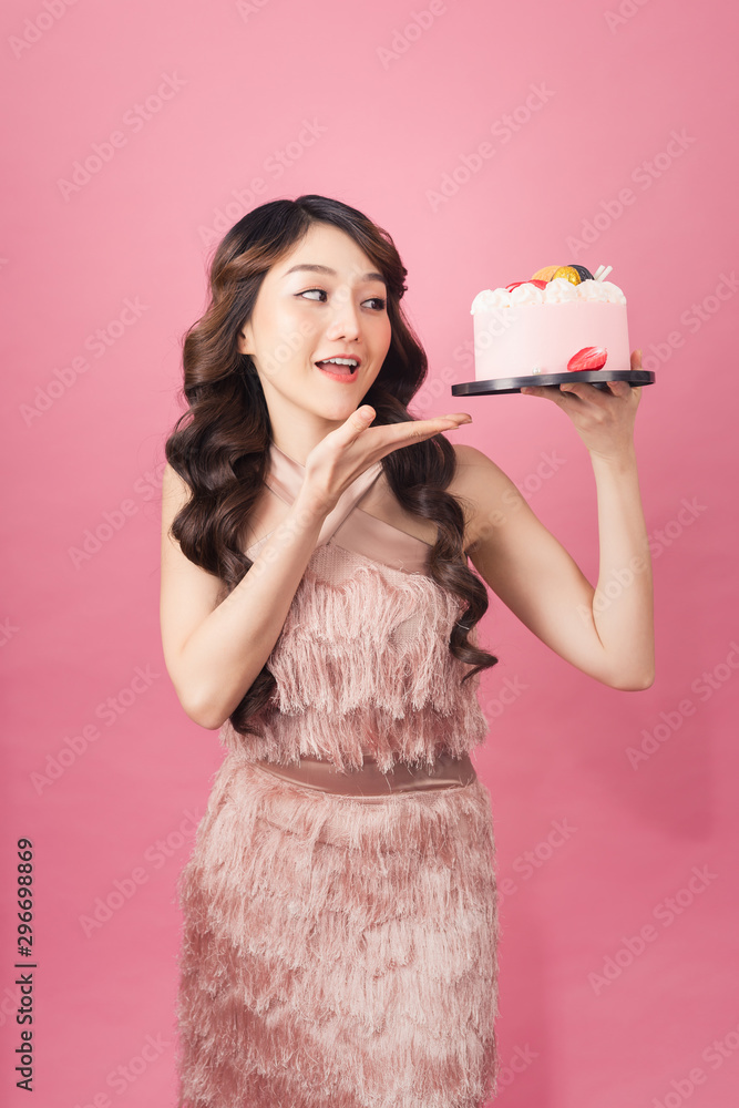 蛋糕正面粉红色背景的快乐女人