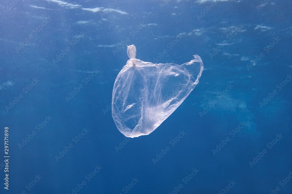 漂浮在蓝色海水中的塑料袋。世界海洋被塑料污染。环境污染