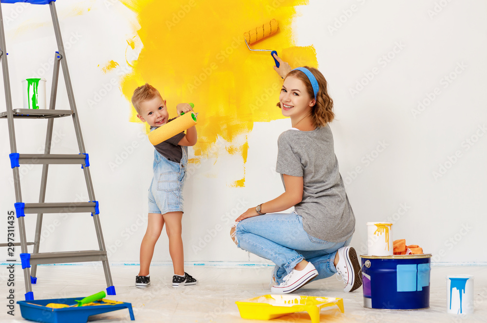 公寓维修。幸福家庭母子粉刷墙壁。