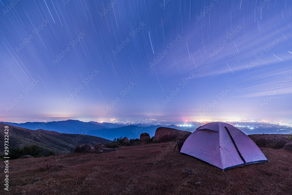 tent at sunset，Tourist hikers tent in mountains at night with stars in the sky 