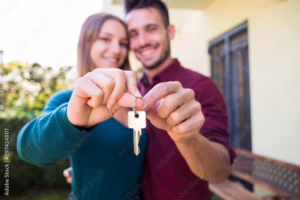 Couple in love holding up new house key