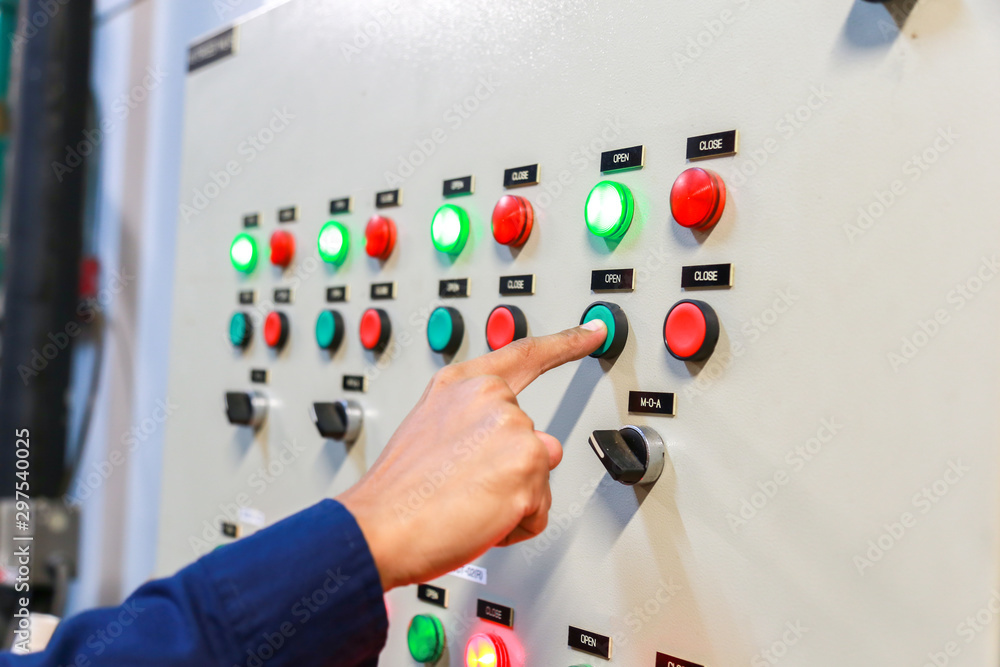 工业技术人员检查发电厂控制面板中的电压或电流状态。