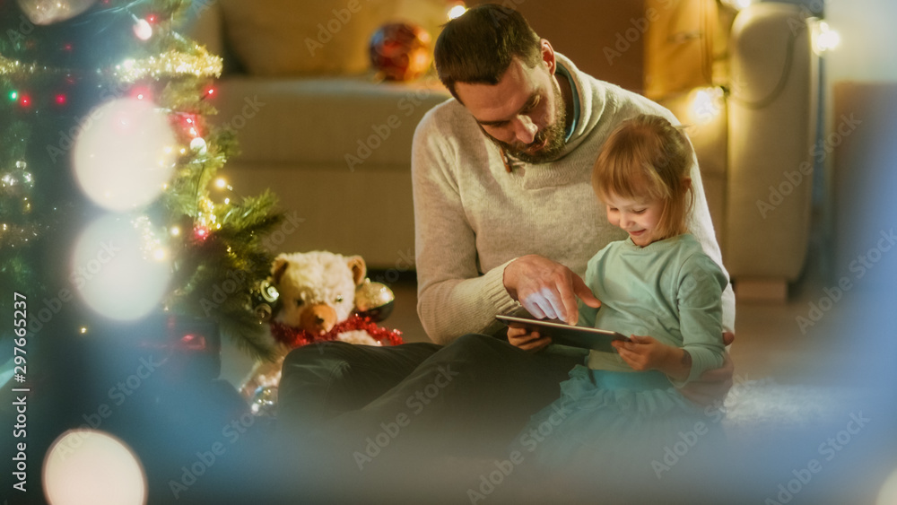透过雪窗看。坐在圣诞三人组下面，下面放着礼物，父亲用平板电脑C