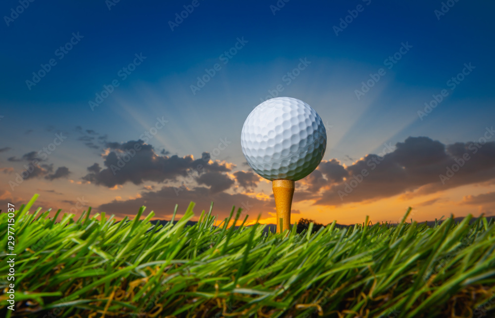 高尔夫球挂在球座上，准备在日落时在高尔夫球场上打球，白天傍晚有云