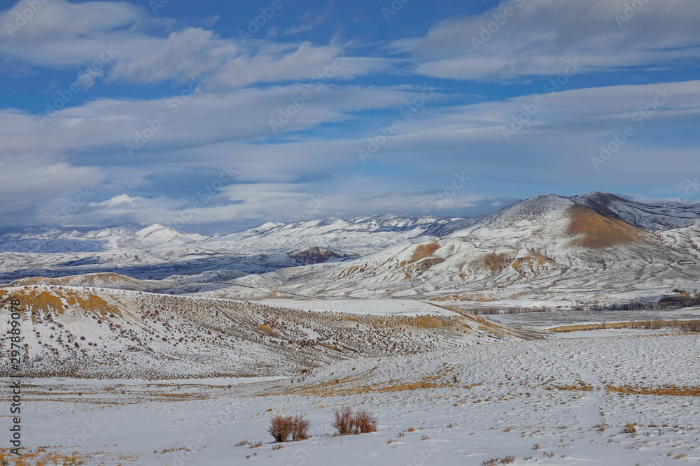 Picturesque view of snowy plains leading to a ridge in the Colorado countryside.