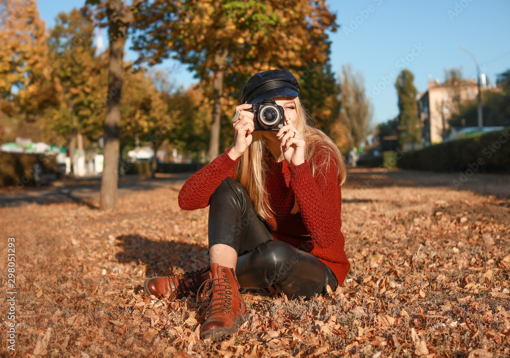 秋天公园里带着现代相机的年轻美女