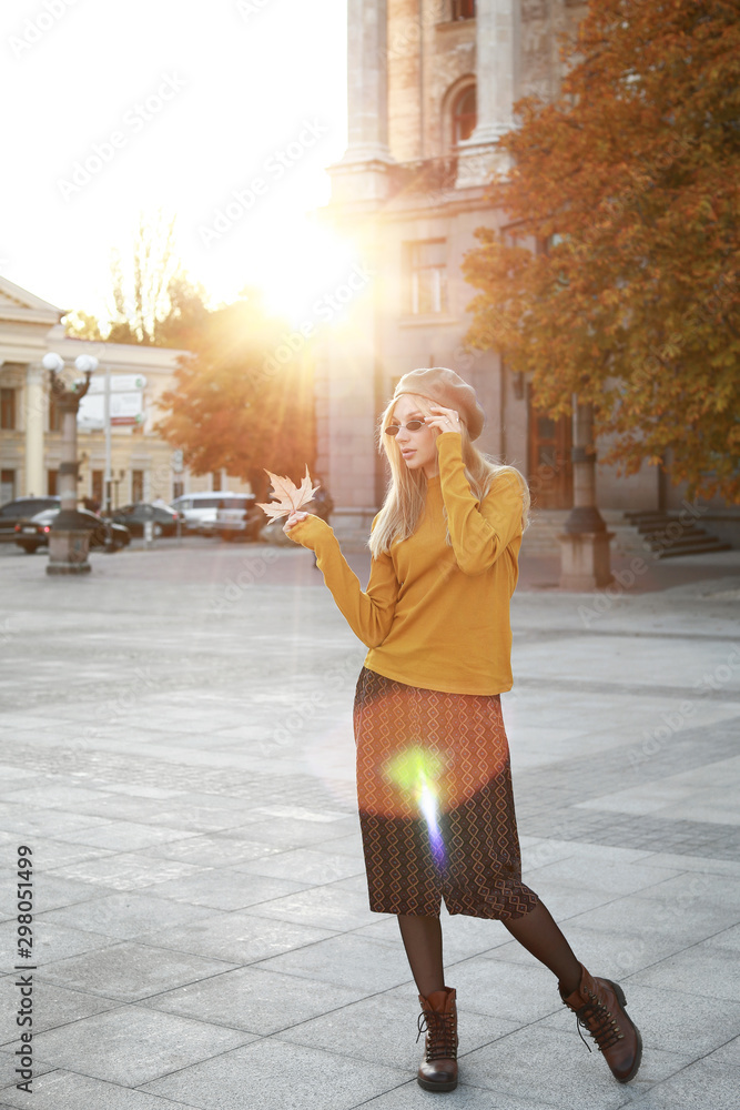 Beautiful young woman in city on autumn day