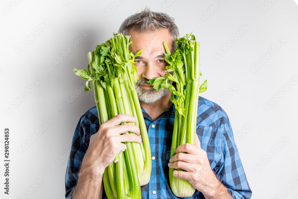 Man holding fresh celery isolated over white background, casual style, healthy lifestyle and healthy