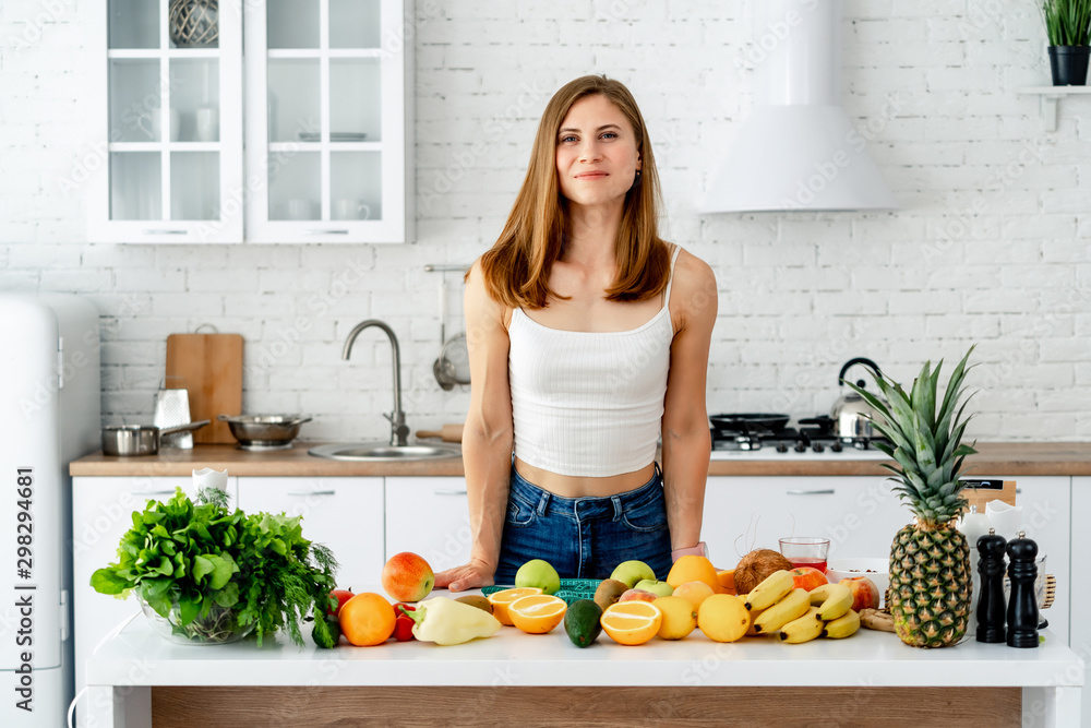 饮食概念。一位身材苗条的健康年轻女性的画像，摆着水果和蔬菜