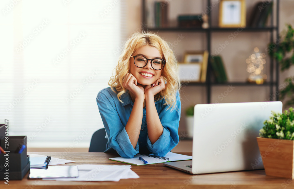 快乐的年轻商务女性在家办公，在电脑上工作