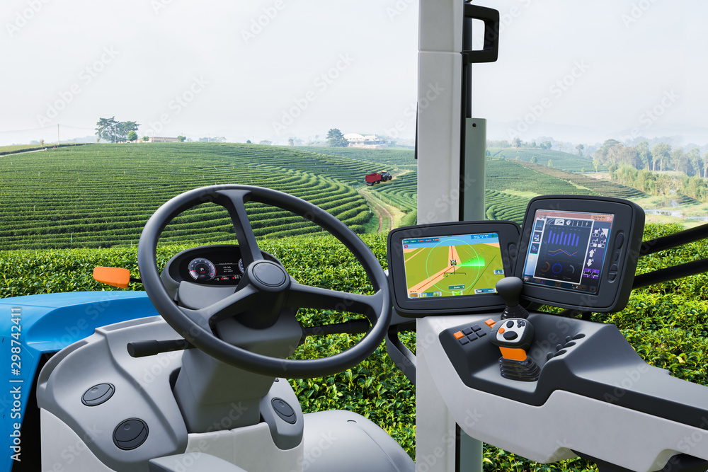 Autonomous tractor working in green tea field, Future technology with smart agriculture farming conc
