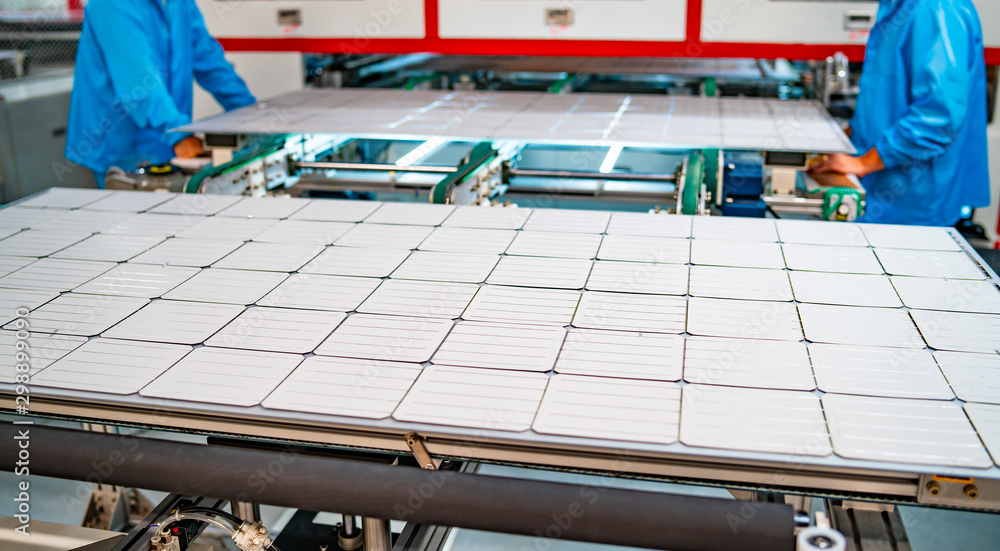 太阳能电池板生产，工人在工厂工作。太阳能生产中重型机械的特写