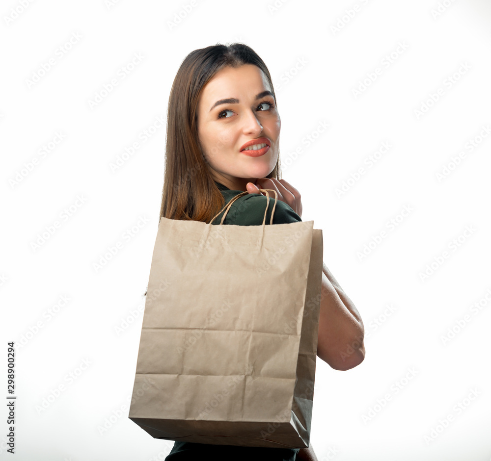 女人拿着白色背景的杂货购物袋。年轻女孩拿着浅棕色的别针
