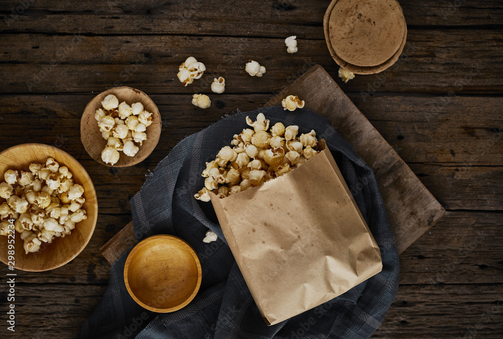 Delicious popcorn with caramel on wooden background..