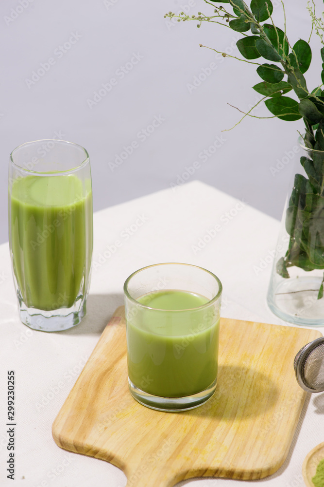 Two green tea glasses on white table. Still life drink
