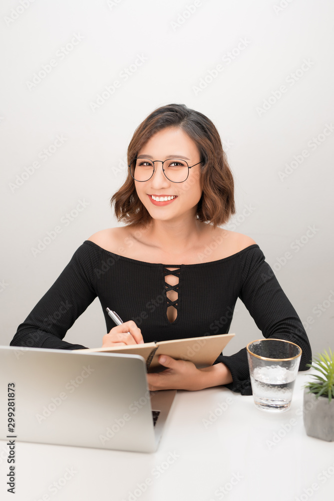 一位拿着笔记本电脑的女商人的肖像写在她办公室的文件上
