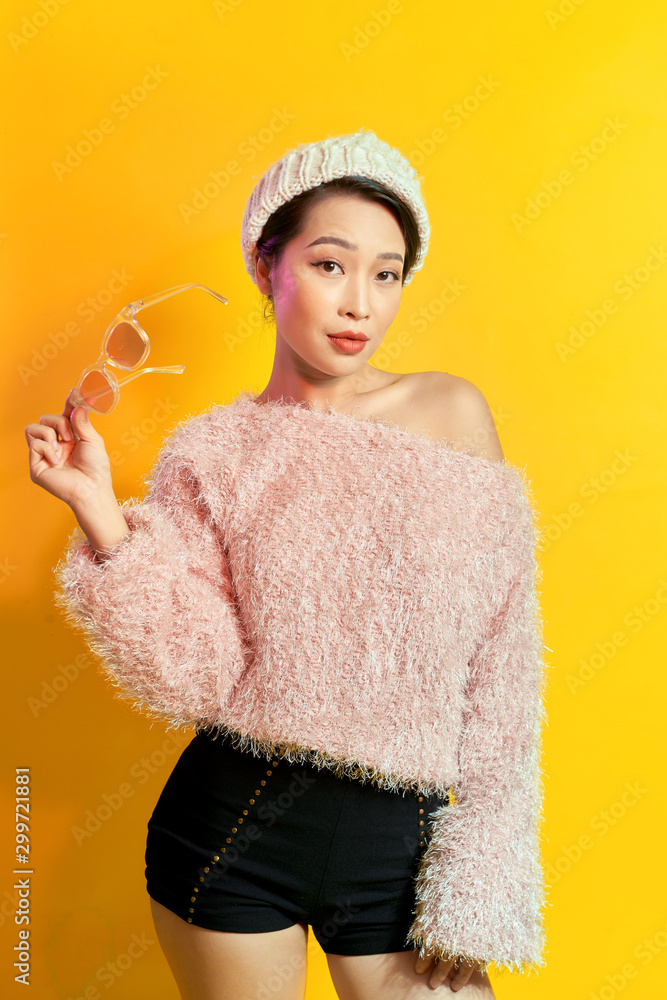 可爱的女人穿着粉色毛皮大衣在拍照时表达了真正的积极情绪。室内肖像