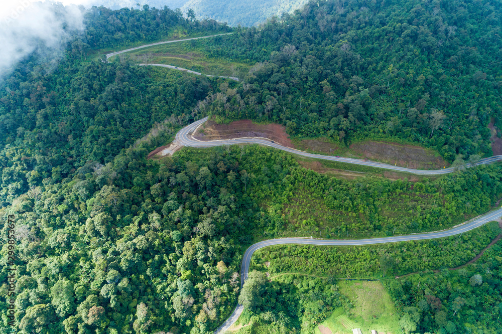 无人机拍摄的热带雨林山地沥青路面弯道鸟瞰图
