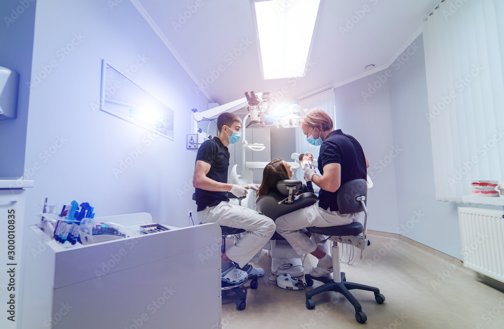 牙医在口腔科用显微镜治疗女性患者的牙齿。牙齿健康问题