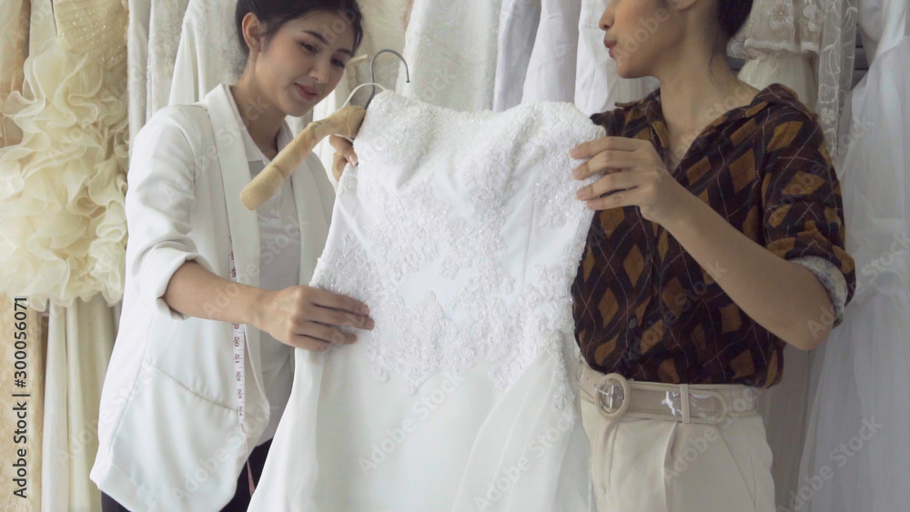 未来新娘客户与婚纱店店主交谈，为其购买婚纱和配饰