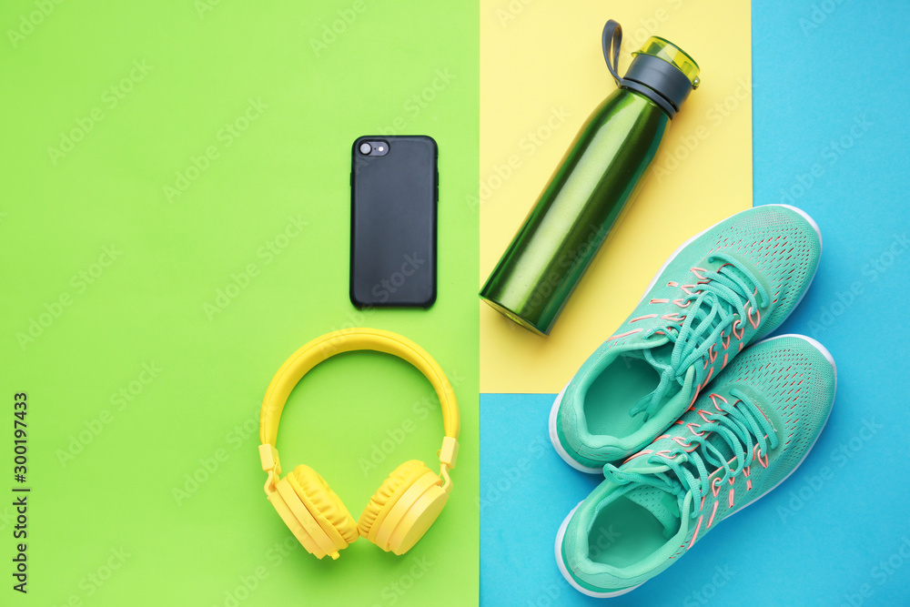 彩色背景运动水瓶、鞋子、耳机和手机