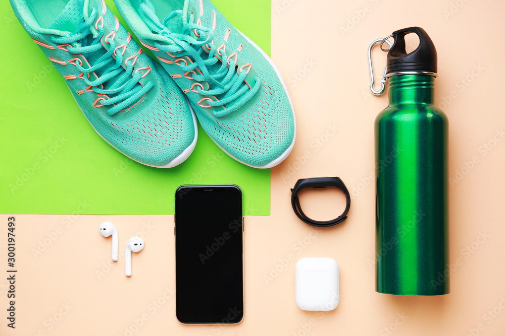 彩色背景的运动水瓶、鞋子、手机和小工具