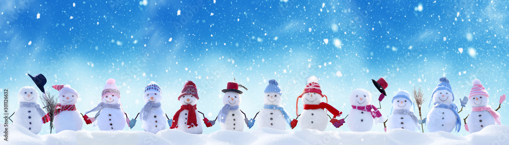 Merry Christmas and happy New Year greeting card with copy-space.Many snowmen standing in winter Chr