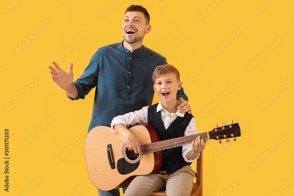 英俊的男人和他的小儿子，背景是彩色吉他
