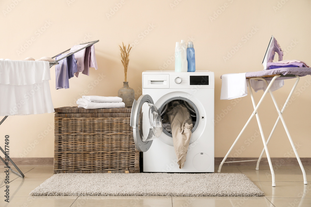 现代洗衣机，靠近彩色墙，配有洗衣机、干衣机和熨衣板